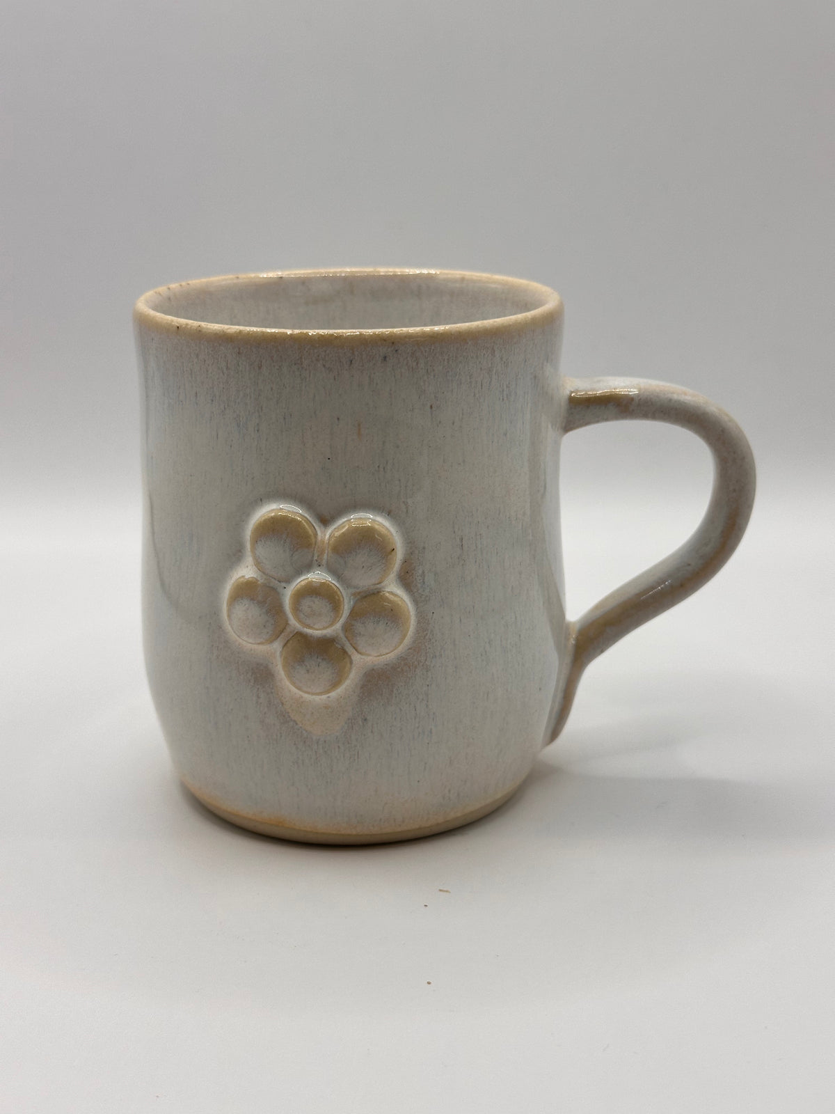 Mudhut Potters Wellington - Curvy cup with handle - White Flux with a daisy - 300ml